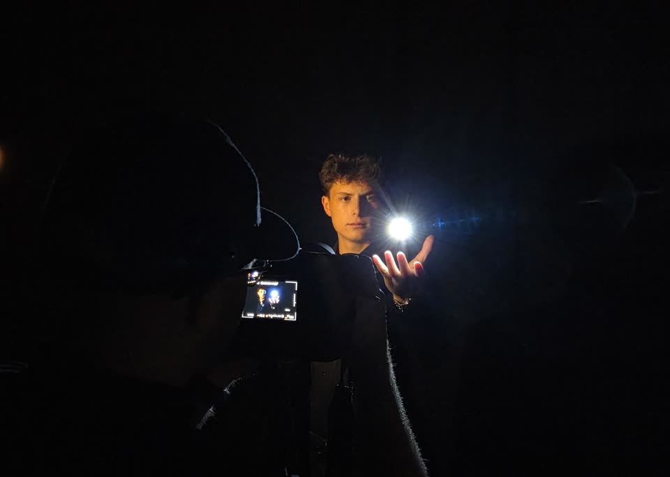 Achter de schermen tijdens een fotoshoot: close-up van een zwevend lichtpuntje boven de hand